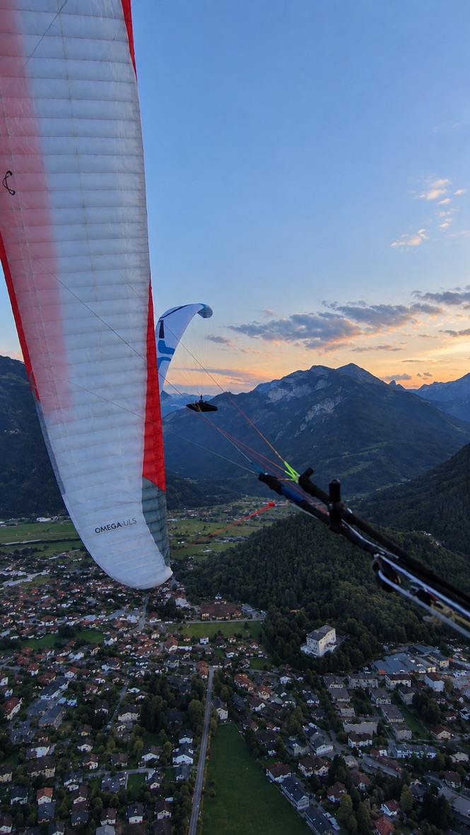 View from a paraglider across mountains and a valley in the evening