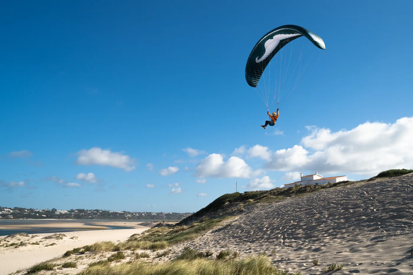 Parakite-Pilot über einer Düne an der portugiesischen Küste