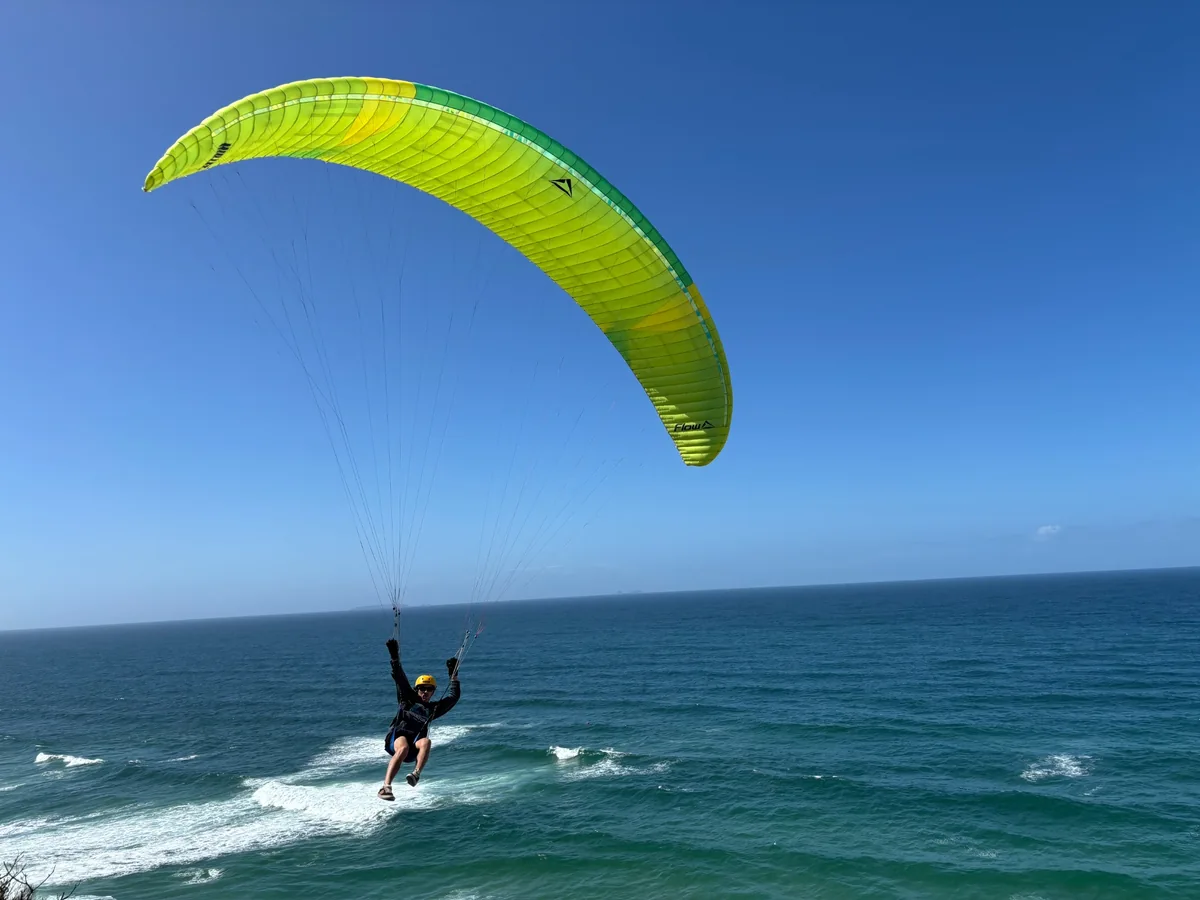 Grüner Parakite mit Pilot vor dem blauen Atlantik