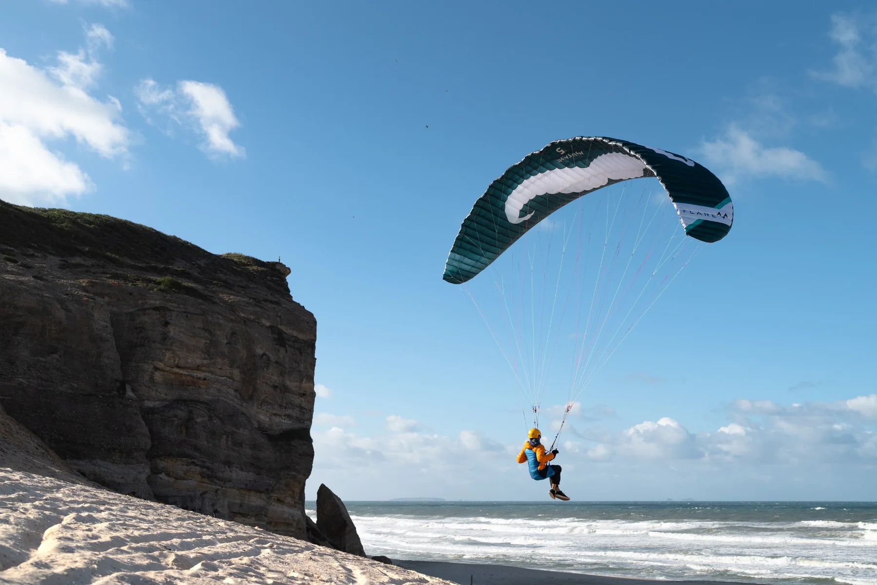 Parakite-Pilot vor einer Felswand am Strand in Portugal