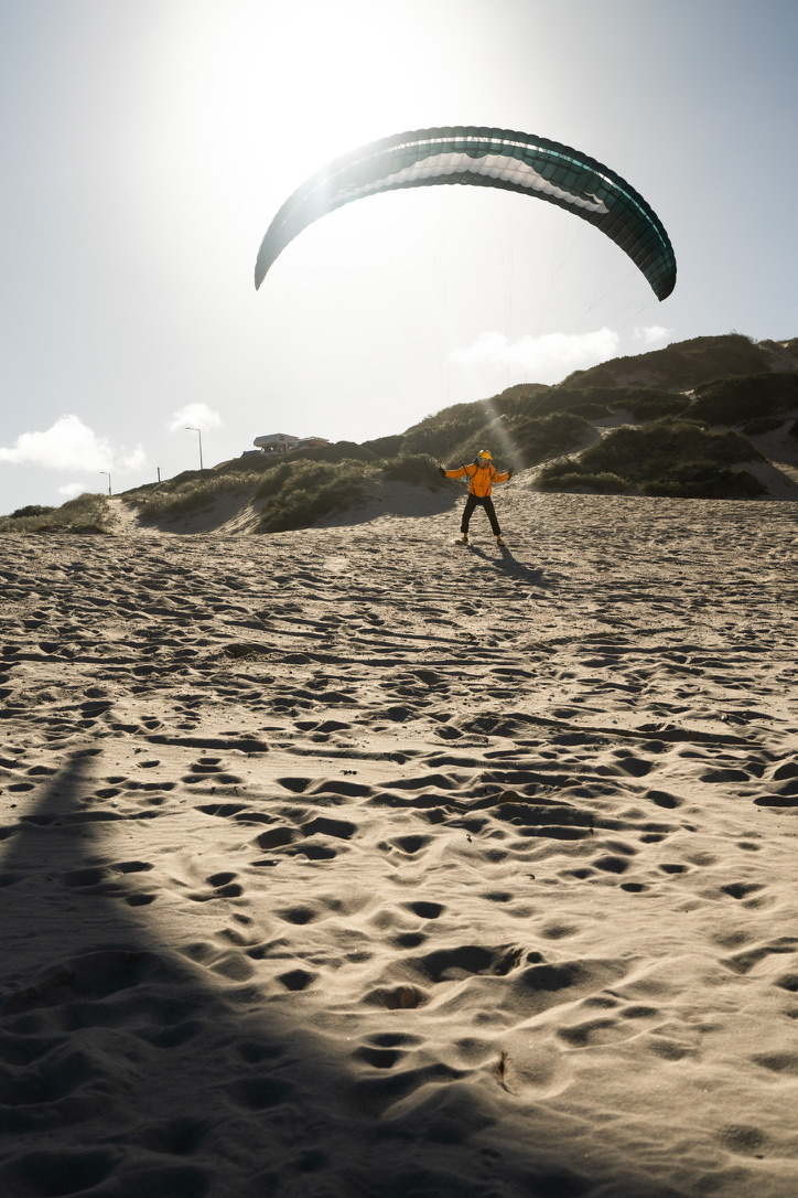Pilot mit seinem Schirm beim Groundhandling am Strand